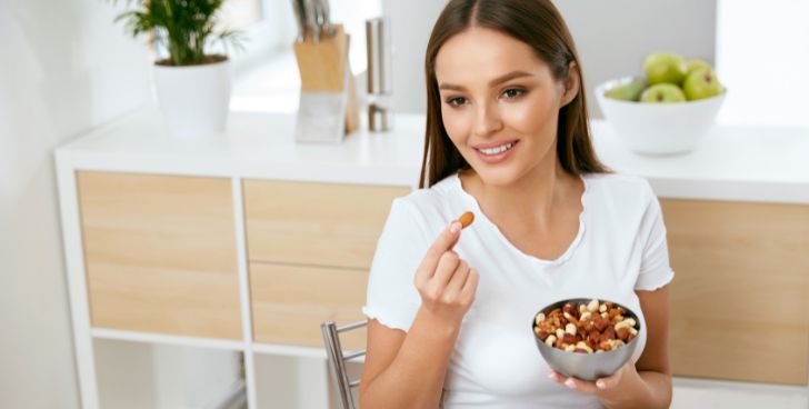 ナッツを間食に食べる女性